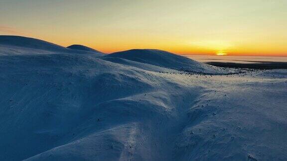 拉普兰的极地之夜在白雪覆盖的丘陵上空鸟瞰