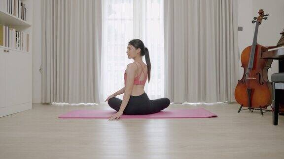 亚洲女性在家做瑜伽时的柔韧性训练