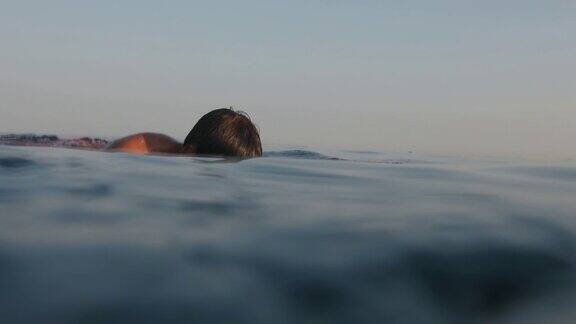 一个十几岁的男孩暑假在海里游泳