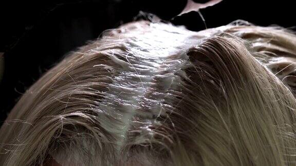 用刷子在发根附近染发染色的头发特写镜头宏