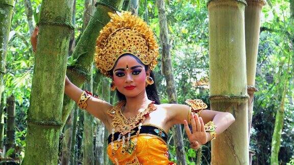 年轻的巴厘舞者在竹林里表演乐贡舞