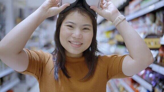 激动人心的亚洲女性穿着vr耳机使用VR-headset眼镜走过metaverse得到体验的虚拟百货商场亚洲女性享受虚拟现实眼镜虚拟购物