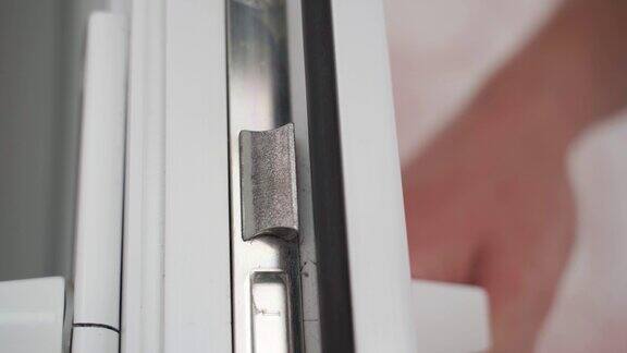 一扇白色塑料门的锁舌特写门把手和门锁操作