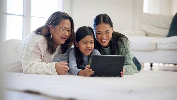 女孩、母亲和奶奶在家里用平板电脑玩电子游戏、看电影和孩子的电子学习应用程序一代幸福的家庭孩子和数字技术流卡通多媒体在地板上