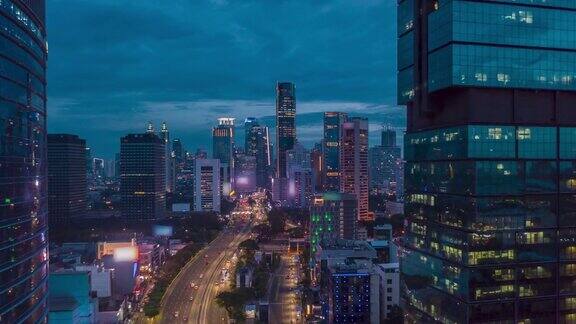 空中摄影hyperlapse拍摄繁忙的夜间交通在多车道高速公路通过现代城市中心与雅加达摩天大楼
