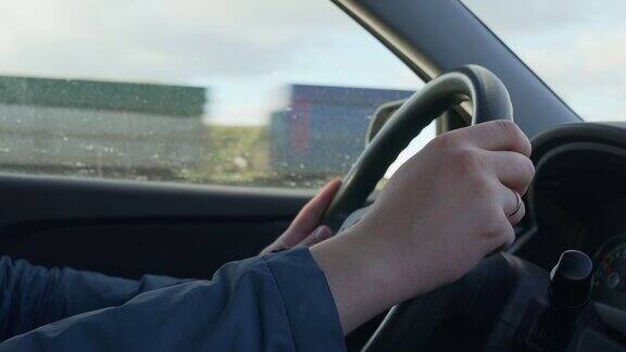 男人开车时把手放在汽车方向盘上