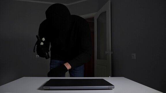 戴面具的窃贼从公寓偷笔记本电脑的钱和珠宝