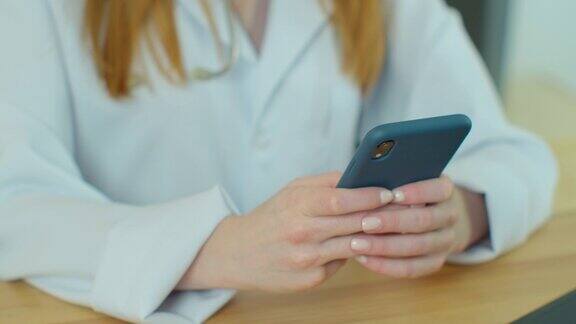 白大褂女医生使用现代智能手机触摸屏设备医生使用手机向患者发送短信告知医疗检查结果