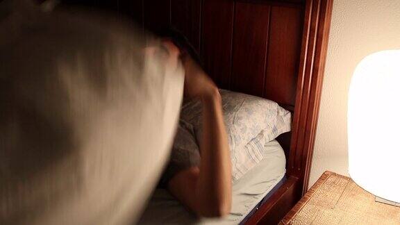 人准备睡觉时从床头灯关上灯年轻人躺在床上睡觉给自己充电