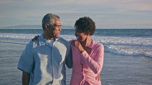 快乐的非裔美国夫妇在海滩上散步