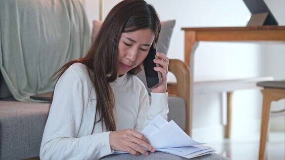 年轻的亚洲女子烦恼债务或错误的每月账单计算费用有财务问题