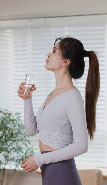 一名妇女在瑜伽练习后喝水