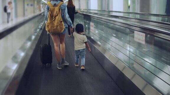 亚洲家庭在机场步行去自动扶梯