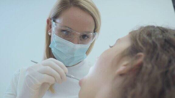 女牙医正在检查女患者的牙齿和牙龈