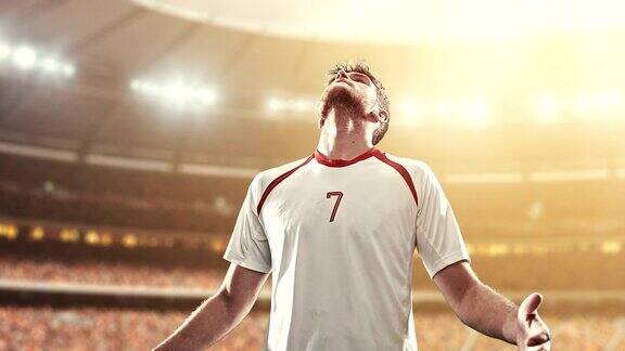 足球运动员庆祝胜利在职业体育场愉快地举起手臂当太阳照耀