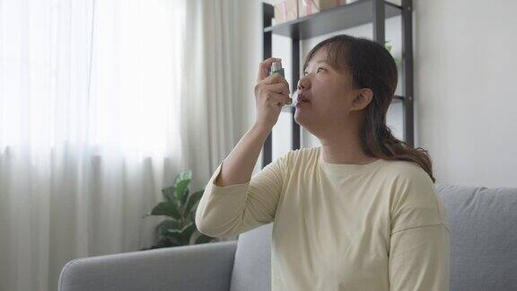 年轻女子在家使用哮喘吸入器