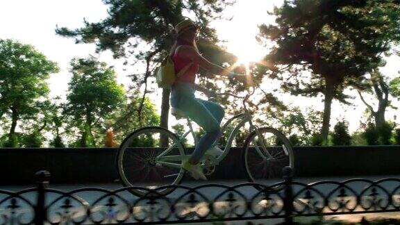 年轻漂亮的女人在公园里骑自行车