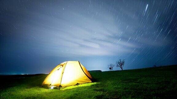 延时发光的帐篷在夜晚的山峦下星星的足迹