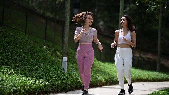 2个亚裔中国女性朋友在公共公园晨练慢跑