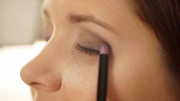 化妆师用刷子在女性眼睛上涂4K眼影
