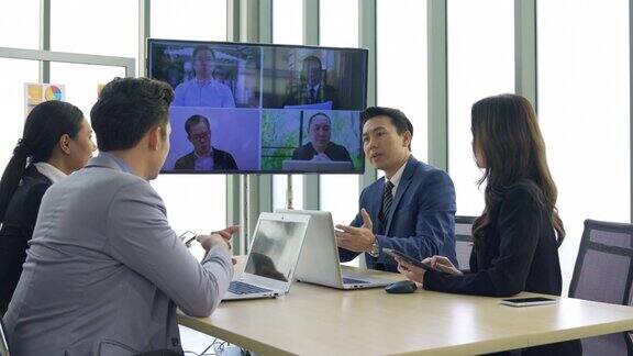 执行业务团队合作会议使用技术在会议室的屏幕上进行在线视频聊天