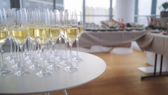几个香槟杯装满起泡酒和办公室派对自助餐