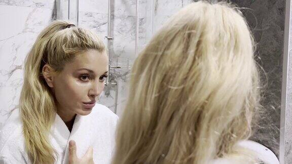 女人在浴室里照镜子照顾自己的皮肤