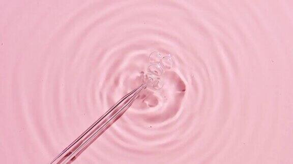 气泡来自粉红色背景上的化学滴管