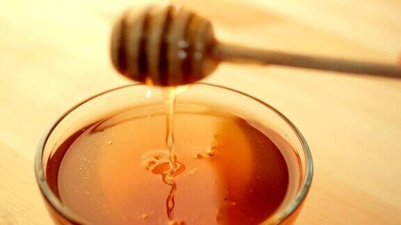 蜂蜜在玻璃碗和蜂蜜滴关闭