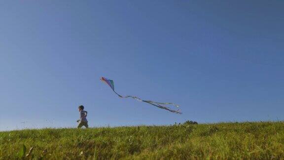 在一个有风的日子男孩拿着五颜六色的风筝