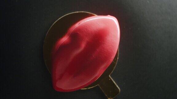 黑色背景上红唇形状的旋转特写美味甜点