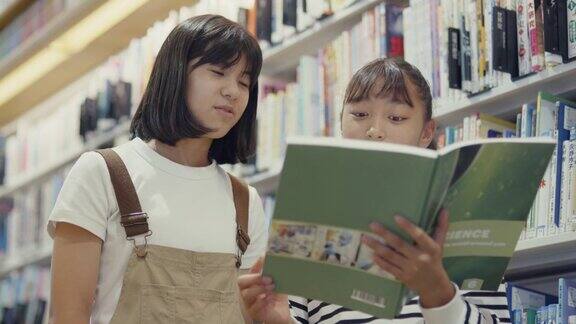 MS两个青春期前的女孩在一起读教科书
