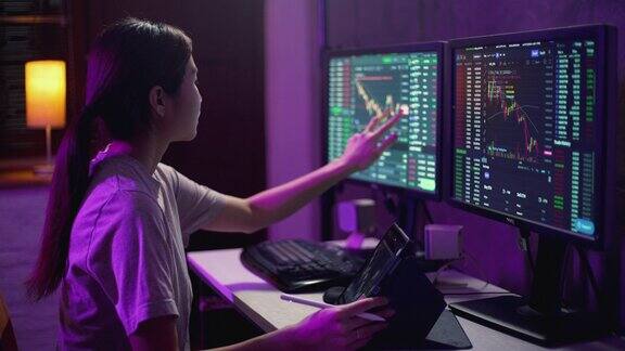 亚洲女性交易员晚上在公寓里用笔记本电脑投资加密货币和股票市场和交易所