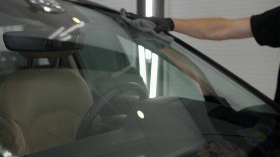 在汽车维修中机械师用超细纤维擦拭挡风玻璃