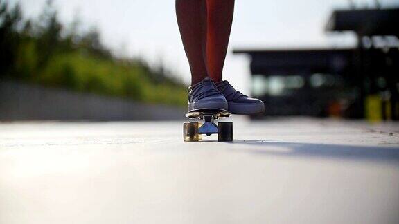 女孩骑着滑板经过镜头画面中是一双穿着运动鞋的腿