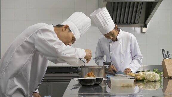 专业亚洲厨师在商业厨房准备和准备餐点