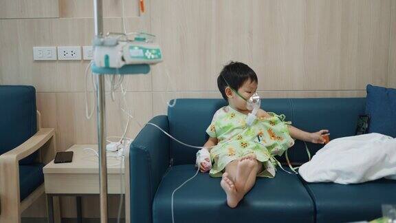 蹒跚学步的男孩在医院接受氧气喷雾器治疗支气管炎和肺病的吸入治疗