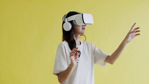 肖像美丽的女人戴着VR耳机在一个黄色的背景