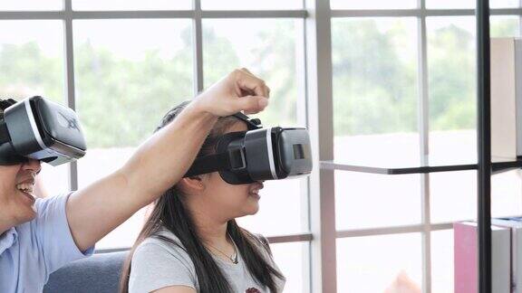 爸爸和女儿戴着虚拟现实眼镜一起玩电子游戏