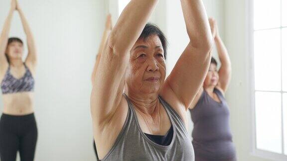 团体高级亚洲妇女锻炼锻炼和练习瑜伽一起在健身房健康高级概念