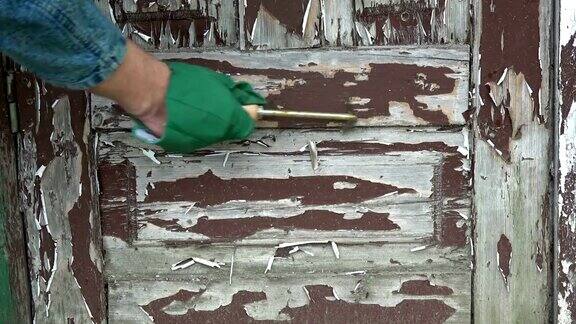 用刮刀刮去木门上的旧漆