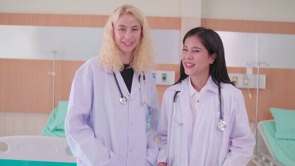 两个女医生在一起聊天看着镜头微笑着