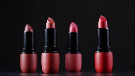 黑色背景上的红色唇妆不同深浅的粉色青铜色口红工作室广告宏观美容理念