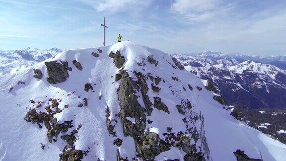 航拍:一个野外滑雪者站在山顶上