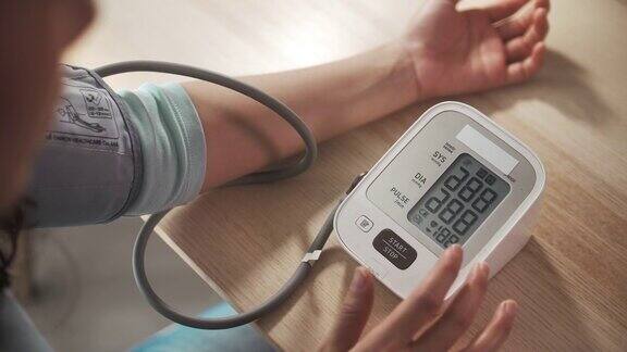 妇女在家检查血压计