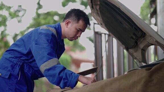 亚洲修理工在车间检查汽车发动机质量保证和服务维修汽车零部件的汽车维修过程发动机维修汽车的服务理念