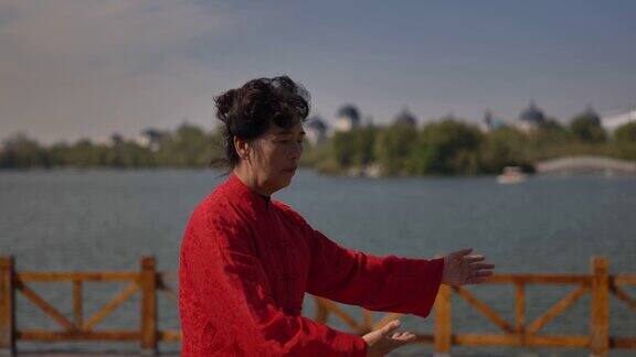 一个女人在湖边练习太极拳