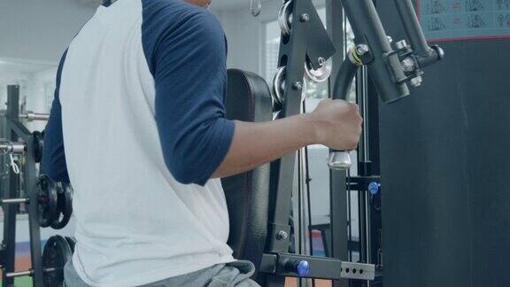 帅哥在健身房的现代积木练习者上训练身体
