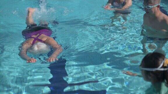 亚洲中国年长妇女学习游泳指导教练在游泳池和她的退休社区在周末上午
