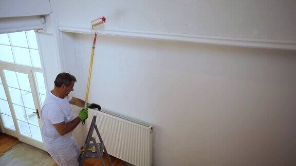一个男画家正在画一堵墙